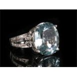 An 18ct white gold aquamarine & diamond ring, the large central aquamarine (approx 7ct) flanked by