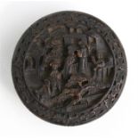 A Chinese tortoiseshell circular snuff box, profusely carved with figures within a foliate border,