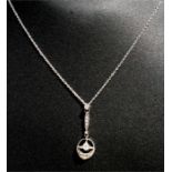 An Edwardian style diamond set drop pendant on a fine white metal chain.