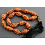 A late 19th / early 20th century Chinese carved heidao nut prayer necklace with seventeen carved