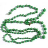 A graduated apple green jade bead necklace with 9ct gold oval shaped carved & pierced clasp, one