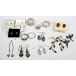 Five silver rings, a pair of silver and amber earrings, and other silver earrings.