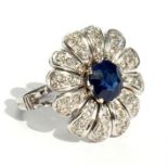 An unmarked white gold sapphire & diamond daisy cluster ring, the central sapphire approximately 1.