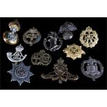 An assortment of eleven military cap badges including Royal Air Force, Highland Light Infantry,