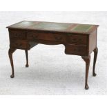 A walnut writing desk, with central frieze drawer flanked by two pairs of short drawers, on carved