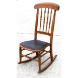 An Edwardian walnut rocking chair, with spindle turned back and upholstered seat.