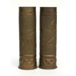 A matching pair of WWI trench art shell case vases decorated with foliage, 27.5 by 9cms.