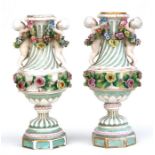 A pair of Meissen style vases, decorated with a pair of cherubs and encrusted with floral and gilt