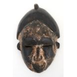 A carved wooden tribal mask, possibly Sepik River origin 24cm 9 1/2 (ins) high
