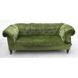 A late 19th century upholstered button back drop arm Chesterfield sofa, on turned front supports,