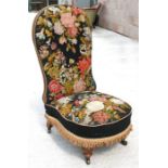 A Victorian woolwork tapestry upholstered nursing chair on turned mahogany legs.