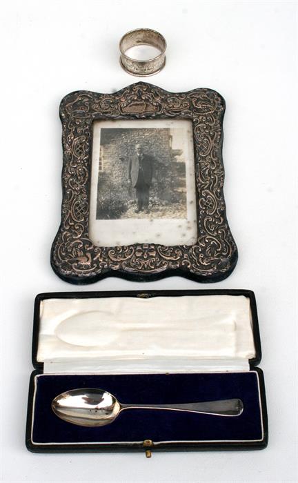 A silver photograph frame, a boxed silver spoon and a silver napkin ring (3).