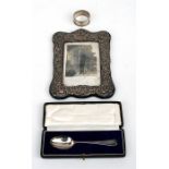 A silver photograph frame, a boxed silver spoon and a silver napkin ring (3).