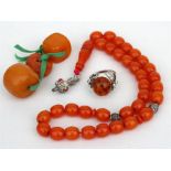 A silver and baltic amber ring; a set of amber style prayer beads and three other beads.