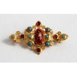 A Victorian gold plated brooch, set with turquoise, garnet, and enamels, 5cm wide.