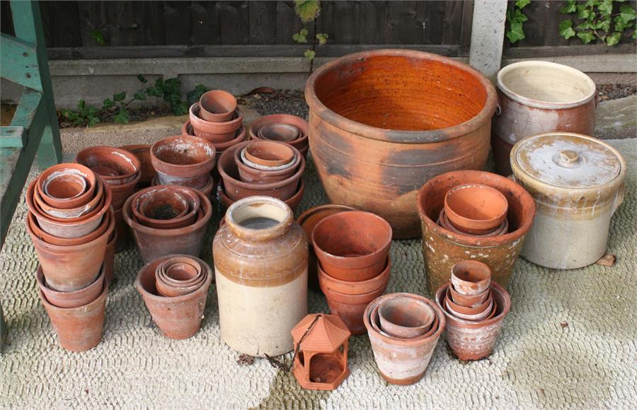 A large quantity of terracotta garden plant pots and other items.