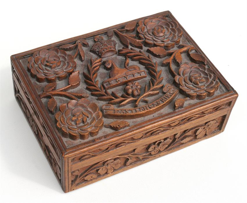 An intricately carved cigarette box with the badge of the East Lancashire Regiment, complete with
