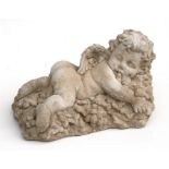 A concrete garden ornament in the form of a recumbent cherub, 28cm (11ins) long.