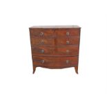 An early 19th century figured mahogany bowfronted chest of two short and three long graduated