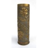 A WWI trench art shell case, elaborately decorated in raised relief with the town of Champagne and