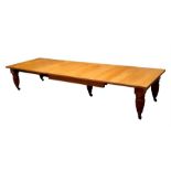 A late 19th century oak extending dining table of large proportions, with four additional leaves,