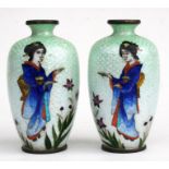 A pair of Japanese Ginbari Cloisonne vases decorated with figures on a graduating green ground,