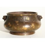 A Chinese bronze gold splash censer with lion mask handles and having a six character mark to the