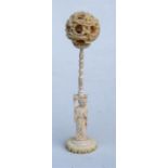 An early 20th century Chinese ivory six layer puzzle ball carved with dragons, on a figural stand,