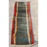 A modern runner rug with red and yellow stripes on a green ground,254 by 88cm (100 by 34.5ins).