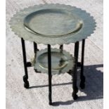 A Chinese two-tier circular brass table on folding lacquer stand, with dragon decoration, 61cm (