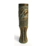 A WWI Trench Art shell case vase, elaborately decorated in raised relief with flowers and foliage,