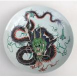A Chinese famille verte charger, decorated with a large dragon holding a flaming pearl with