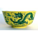 A Chinese footed bowl decorated with dragons chasing a flaming pearl on a yellow ground, having a