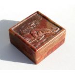 A Chinese carved soapstone box, the top depicting a tiger, conatining a seal with four character