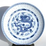 A Chinese blue & white rice grain shallow dish decorated with a central dragon and flaming pearl,