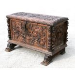 A 19th century Spanish walnut coffer, highly carved with figural scenes, with label to the inside '