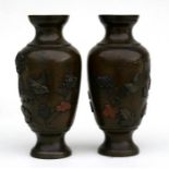 A pair of Japanese Meiji period (1880) bronze and mixed metal vases, decorated in relief with