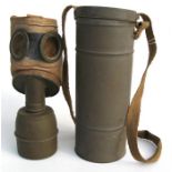 A WWII gas mask in a metal container.