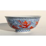 A Chinese porcelain footed bowl, decorated with red oxide dragons, horses and mythical beasts, and