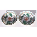 A pair of 19th century Chinese shallow bowls, decorated with dragons and phoenix around a flaming