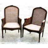 A pair of early 20th century walnut bergere armchairs with upholstered seat pad and arm tops, on
