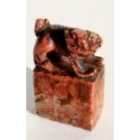 A 19th century figured rouge soapstone seal in the form of a Fo dog, 6cm (2.25ins) high.