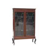 A mahogany display cabinet on stand, the pair of astragal glazed doors enclosing a shelved