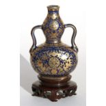 A Chinese blue & gilt two-handled double gourd vase, decorated with foliate scrolls with gilded seal