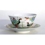 A Chinese porcelain tea bowl and saucer, decorated with birds and flowers in enamel colours and