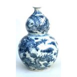 A late 19th / early 20th century Chinese blue & white double gourd vase, the decoration dragons