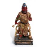 A Chinese carved wood and gilt polychrome figure of Guan Yu dressed in ornate dragon motif armour,