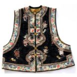 A late 19th / early 20th century Chinese silk waistcoat, embroidered with bats and flowers on a deep