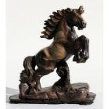 A large Chinese carved soapstone figure of a leaping horse, on a hardwood stand, 38cm (15ins) high.