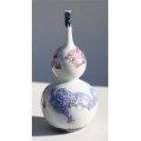 A Chinese porcelain double gourd vase decorated in slight relief with pink and blue dragons